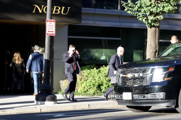 Secretary of Homeland Security, Alejandro Mayorkas pics up two bags of take away food from high end restaurant Nobu.